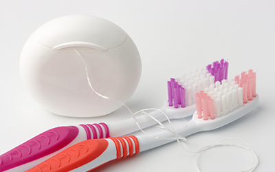 An image of a toothbrush and floss