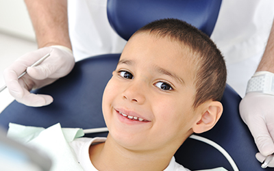 Young boy sitting in dental chair smiling