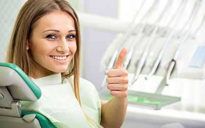 Young girl in dental chair with thumbs up