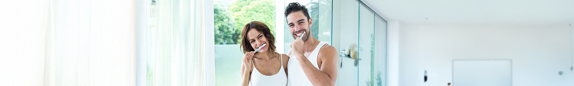 Happy couple brushing their teeth.