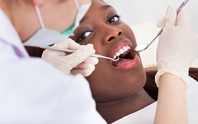 A dentist checking the teeth of a woman