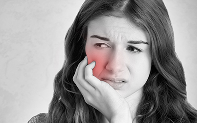 A woman holding the side of her face