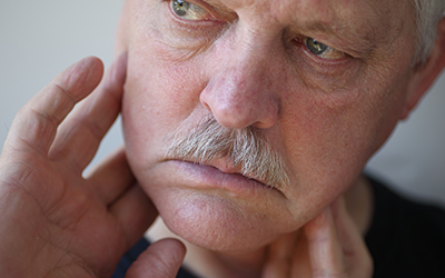 Man with fingers on painful jaw