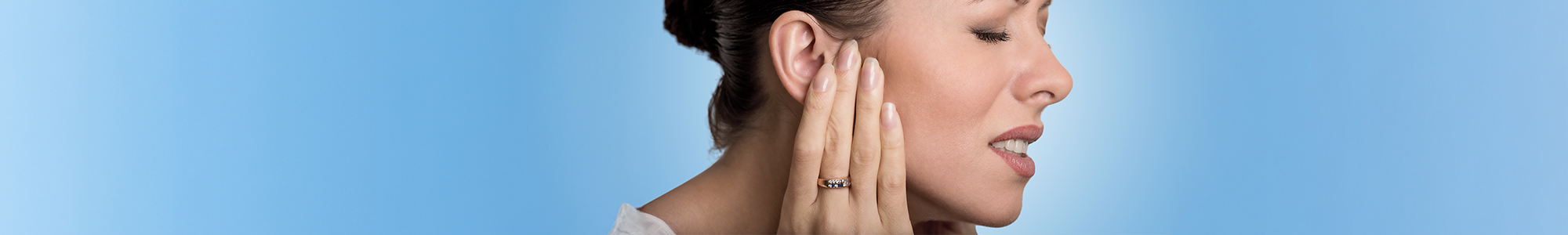 Woman in pain holding her temporomandibular joint