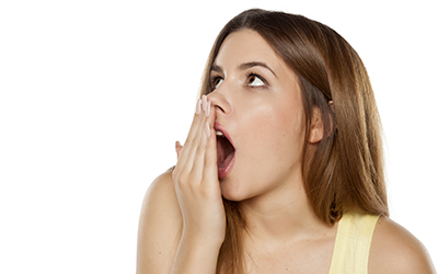 A woman covering her mouth with bad breath