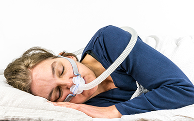 A woman sleeping on her side with a cpap machine