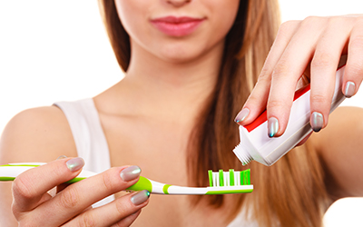 Woman putting toothpaste on her toothbrush