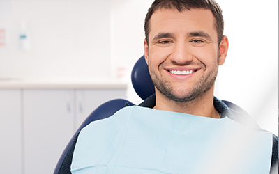 A man sitting in a dental chair smiling