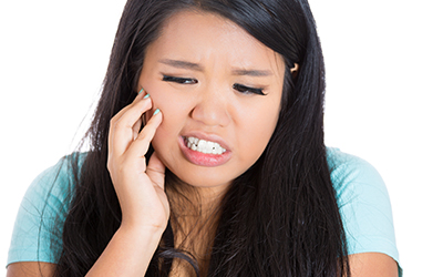 A girl holding the side of her jaw