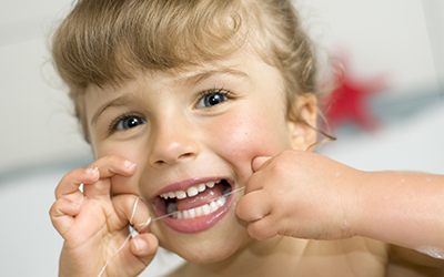 A young child flossing