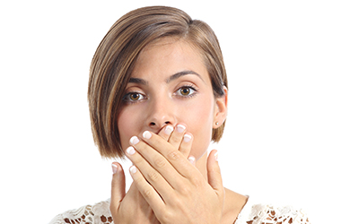 Woman covering her mouth due to bad breath